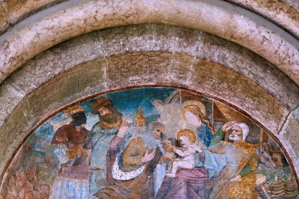 Vallouise - glise Saint-tienne - Portail  plein cintre et tympan avec une peinture du XVIe sicle reprsentant l'adoration des rois mages